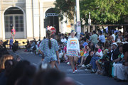 Outdoor fashion show with models on the runway surrounded by seated audience.